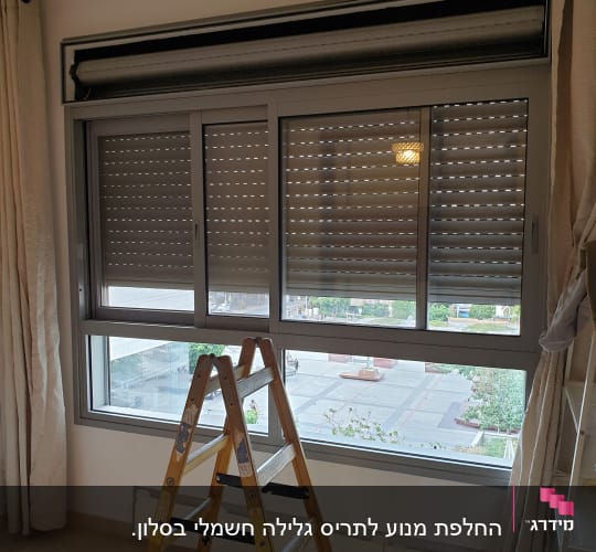 תריסים סגורים על חלון עם סולם עץ לידם